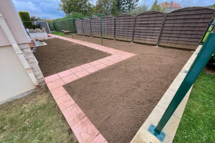 Terrain préparé et nivelé avec allée en dalles roses posées, sol meuble prêt pour engazonnement, Garden & Co paysagiste Belgique Luxembourg